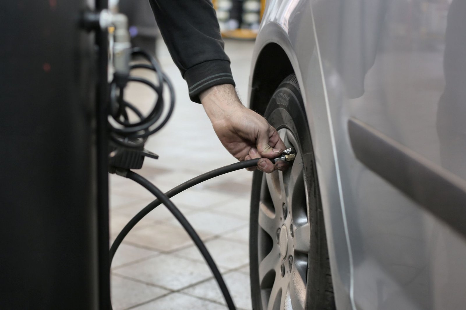 A precision digital tire pressure gauge with an air release valve sits on concrete.